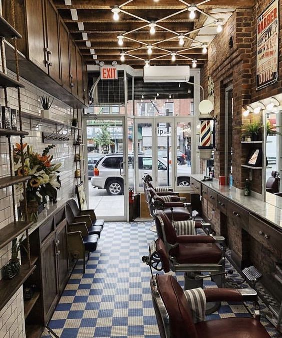 Interior de una barbería donde predomina el color café. Con el piso ajedrezado azul y blanco